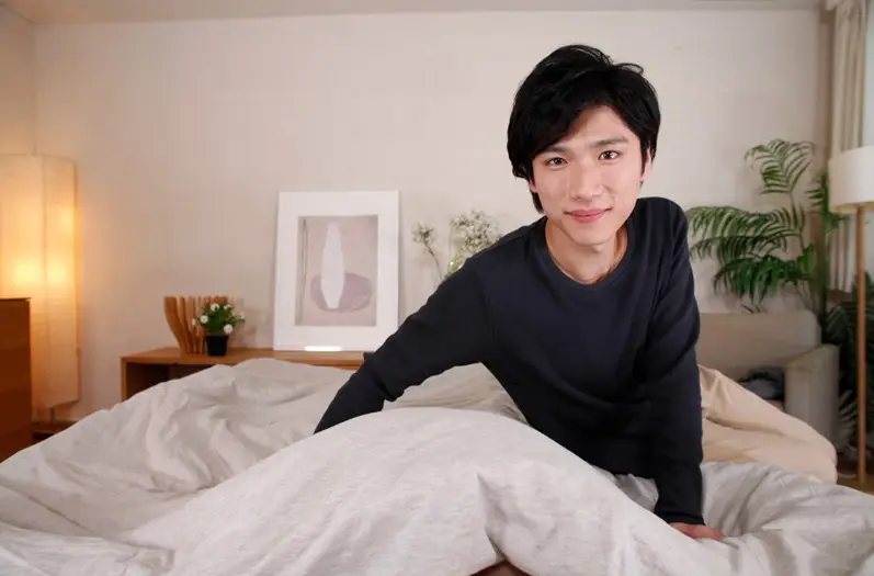 布団越しにこちらを見下ろしながら微笑む有馬芳彦