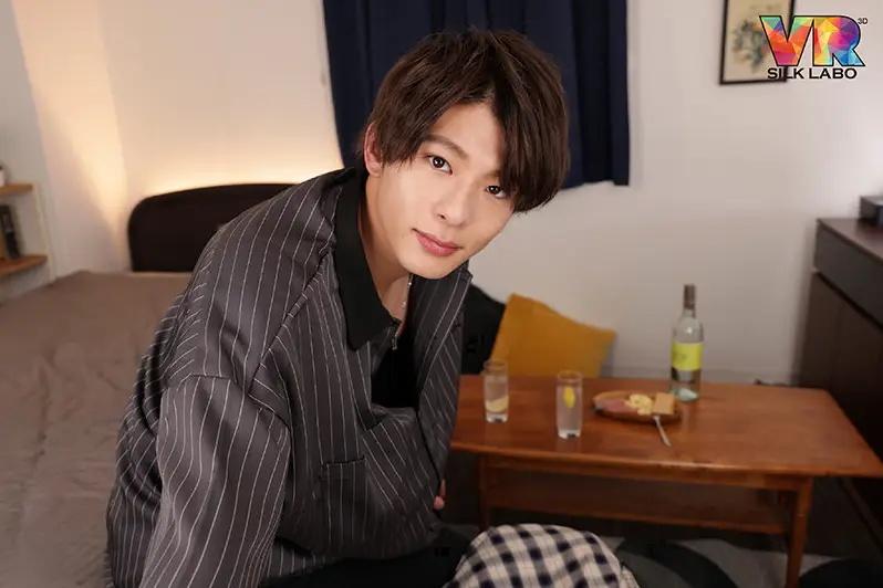 こちらを見つめる東雲怜弥。テーブルにはお酒とおつまみ